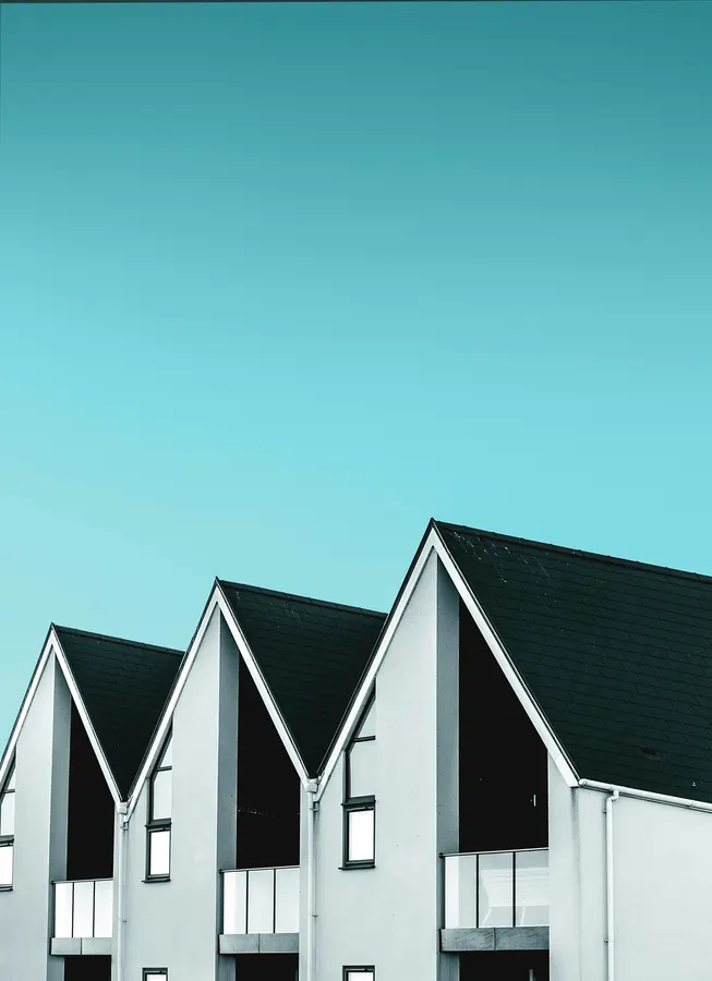 Row of white gable roofs against a clear sky