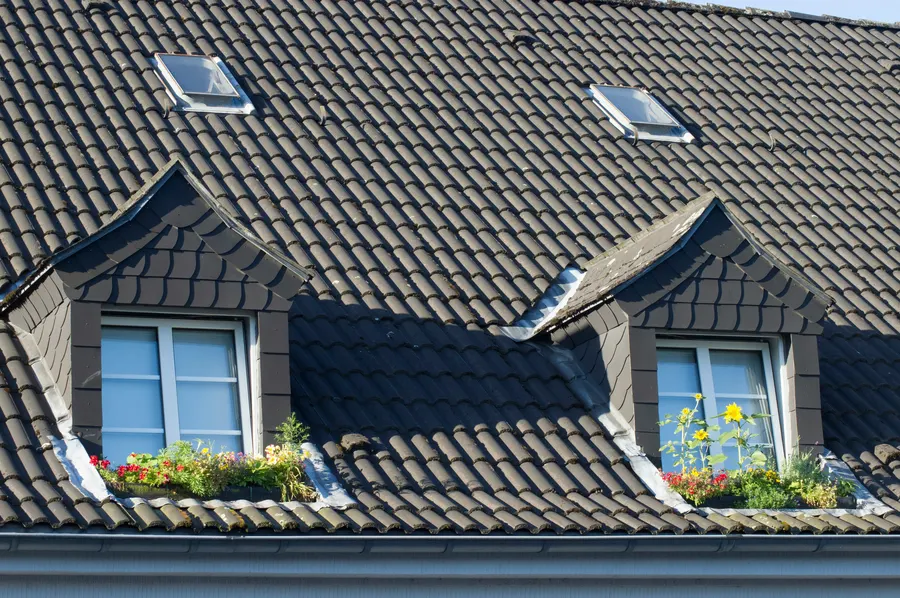 Dark tiled roof with dormer windows and window boxes